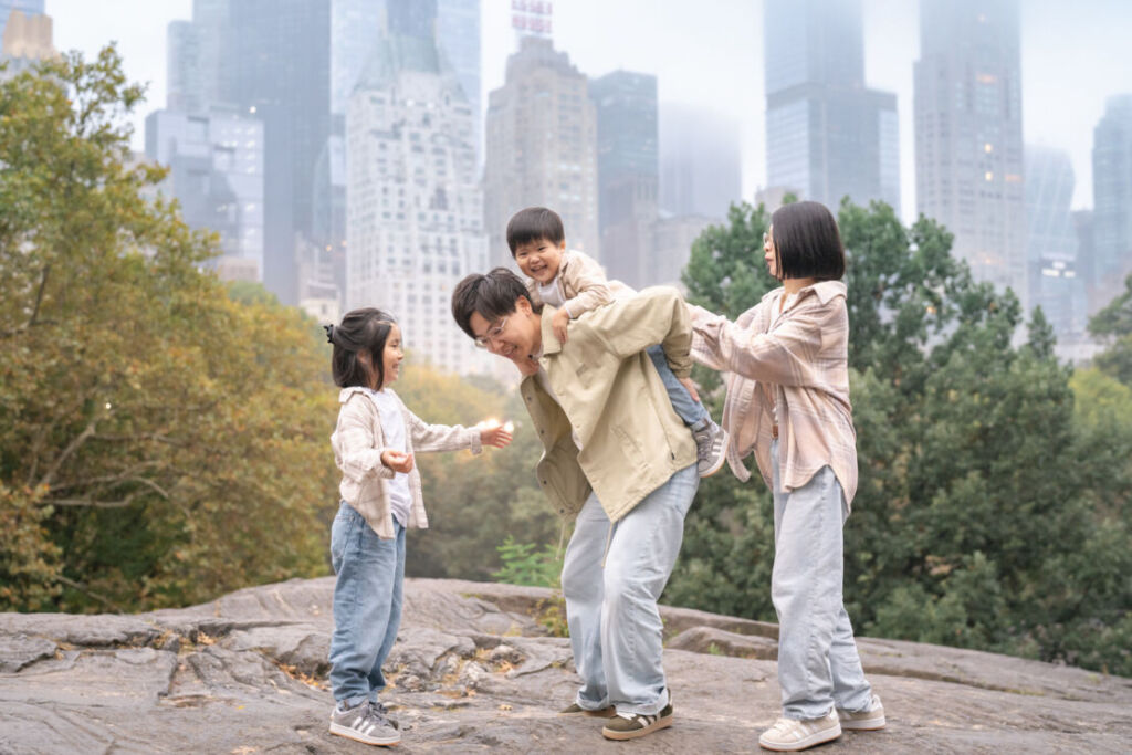 ニューヨークでファミリーフォト/ラットロックの上でお子様をおんぶしようとしているパパ。