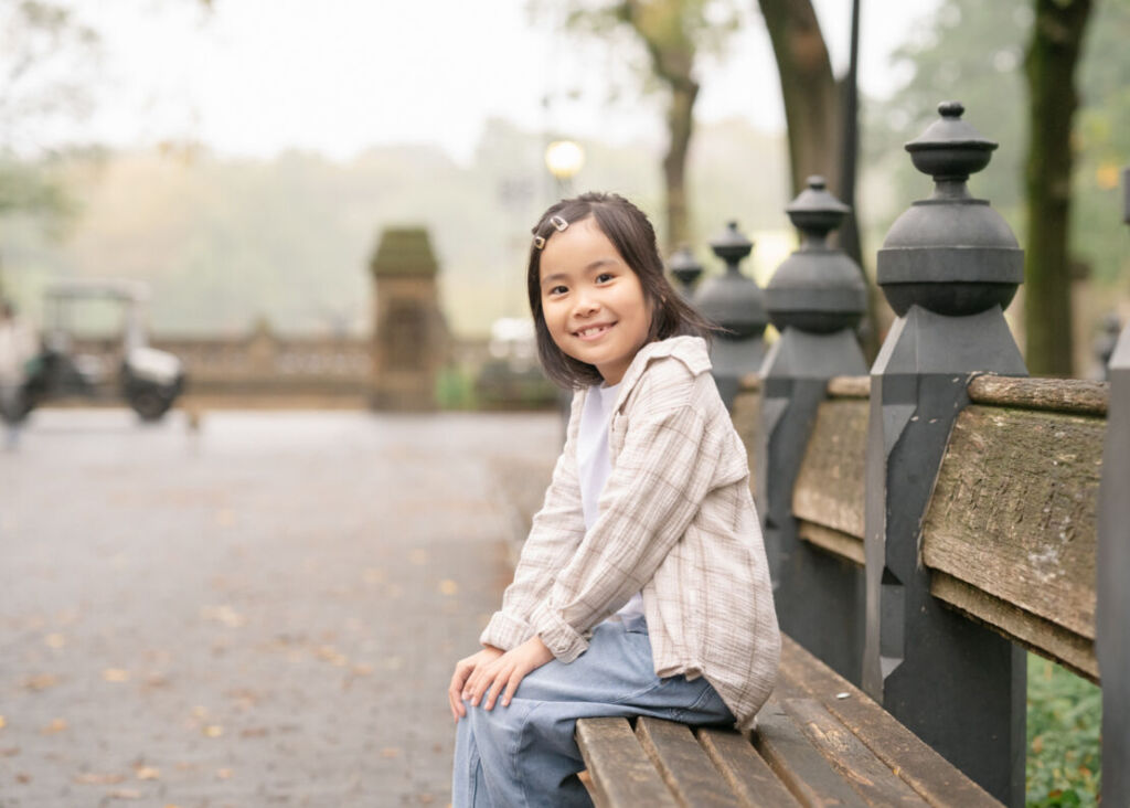 ニューヨークでファミリーフォト/ザ・モールのベンチに座るお姉ちゃん。