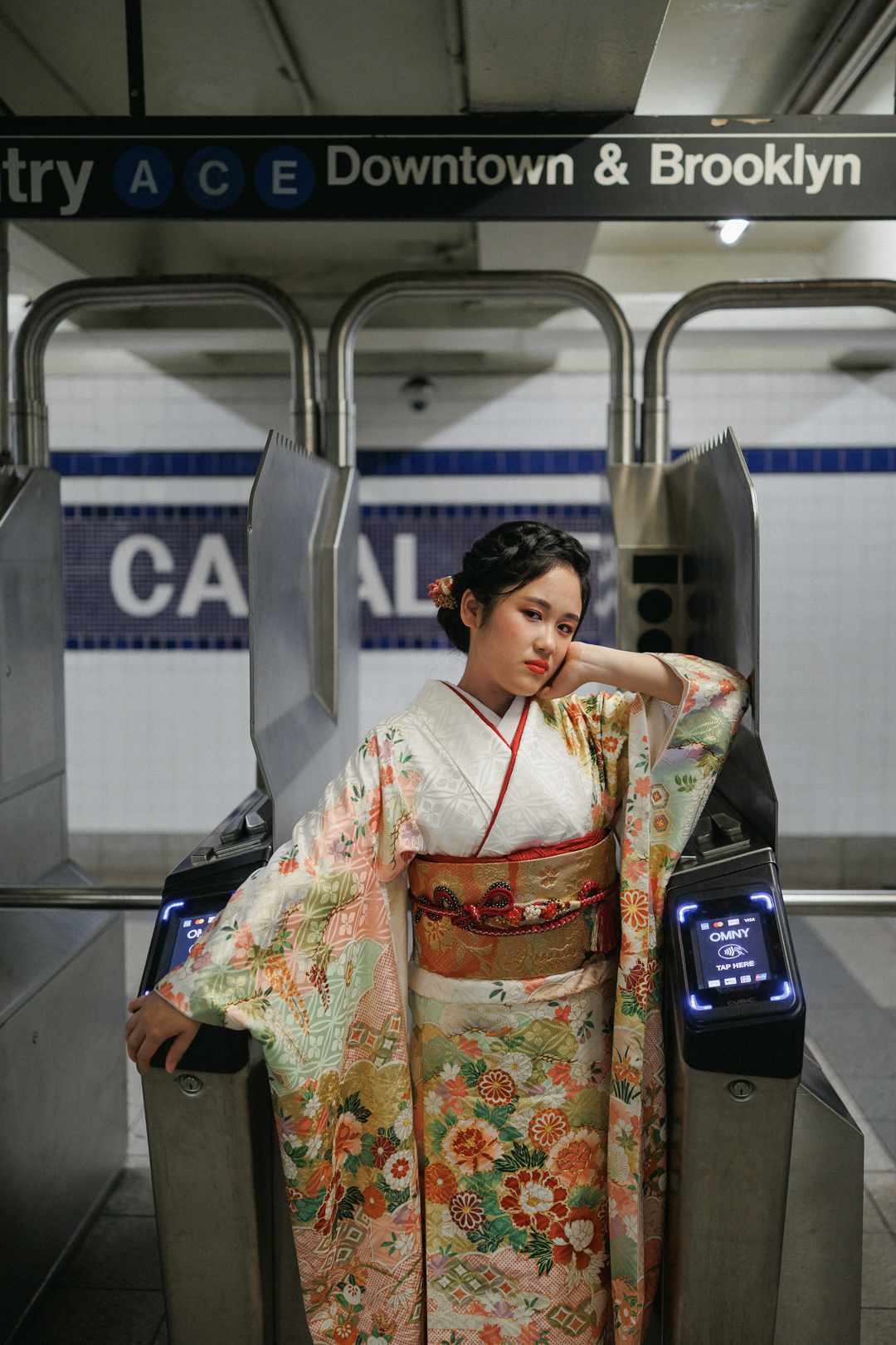 ニューヨークで成人式フォト/地下鉄の改札に、振り袖姿の女性が立つ。