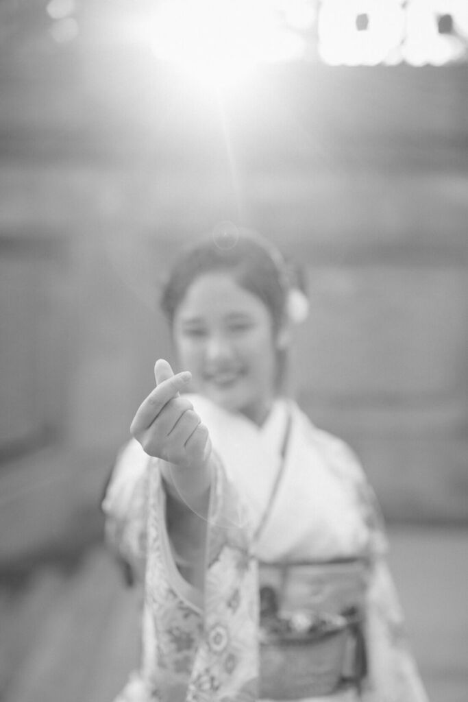 ニューヨークで成人式フォト/指ハートを作る振り袖姿の女性。
