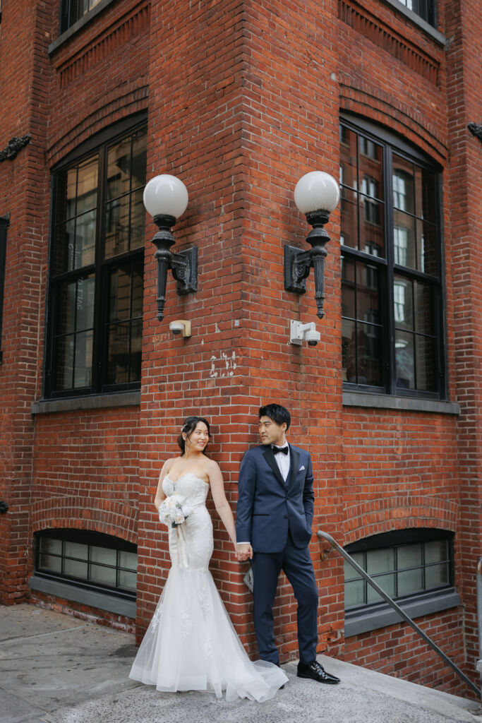 ニューヨークのフォトウェディング|前撮り/ワシントンストリートの片隅で手をつなぐ花嫁と花婿。