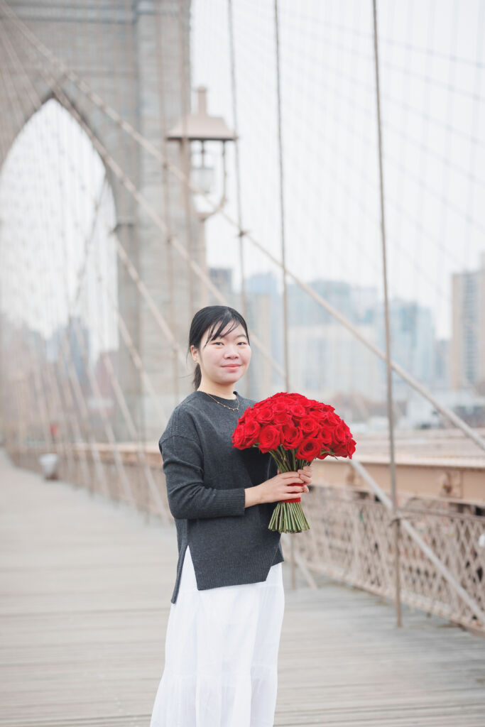ニューヨークでファミリーフォト/ブーケーを手にブルックリン橋に立つご長女。
