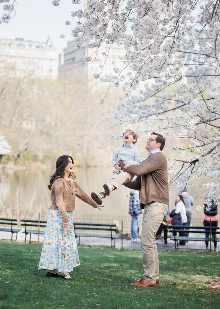 ニューヨークのファミリーフォト/セントラルパークの桜の木に顔を近づける男の子。
