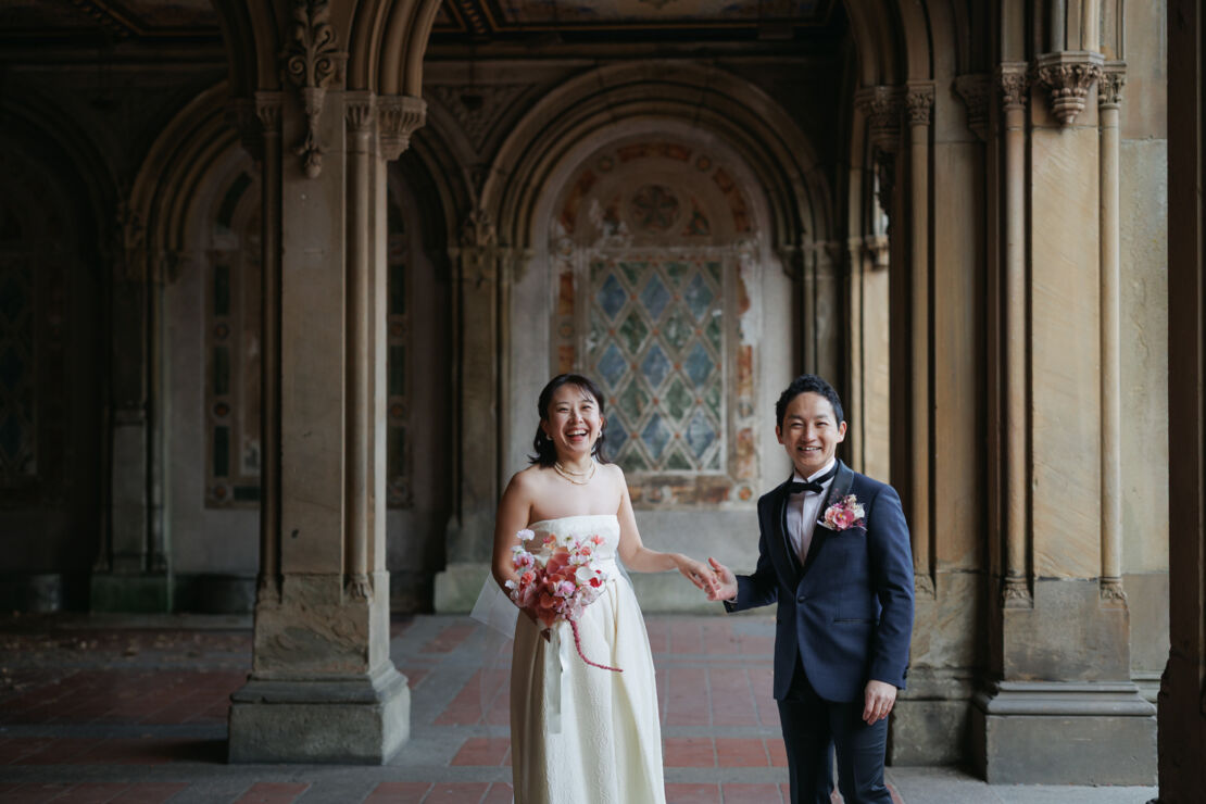 ニューヨークの前撮り|ウェディングフォト/ベセスダテラスのアーケードに立つ花嫁と花婿。