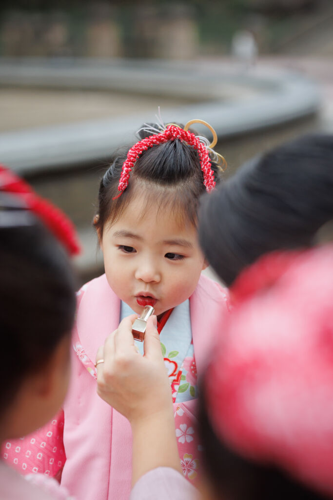 ニューヨークで七五三フォト/ママにリップを塗ってもらう三つ子ちゃん。