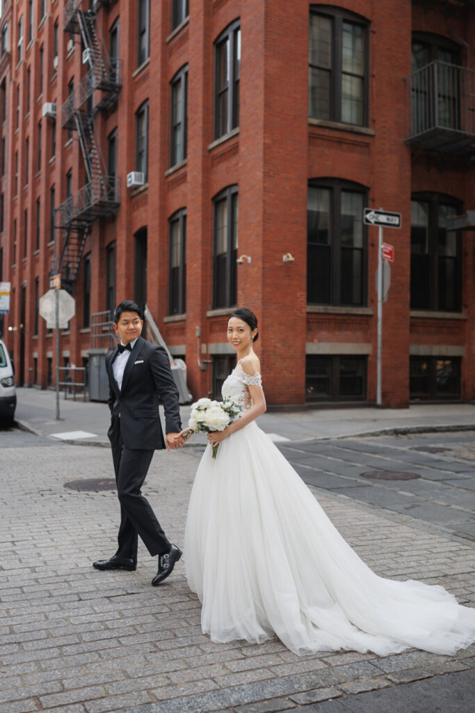 NYウェディングフォト|前撮り/レンガ色の背景にウェディングドレスの純白が映える。