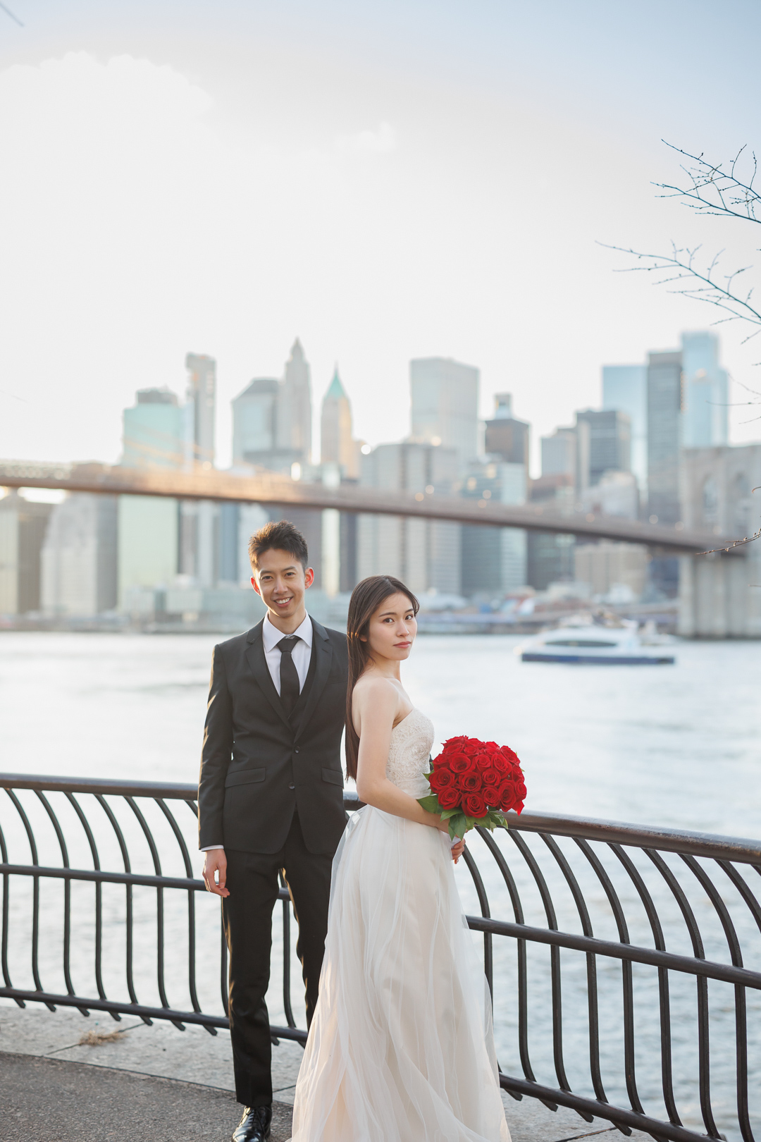 ニューヨークで後撮り/フォトウェディング|ブルックリンブリッジパークの川沿いに立つ花嫁と花婿。