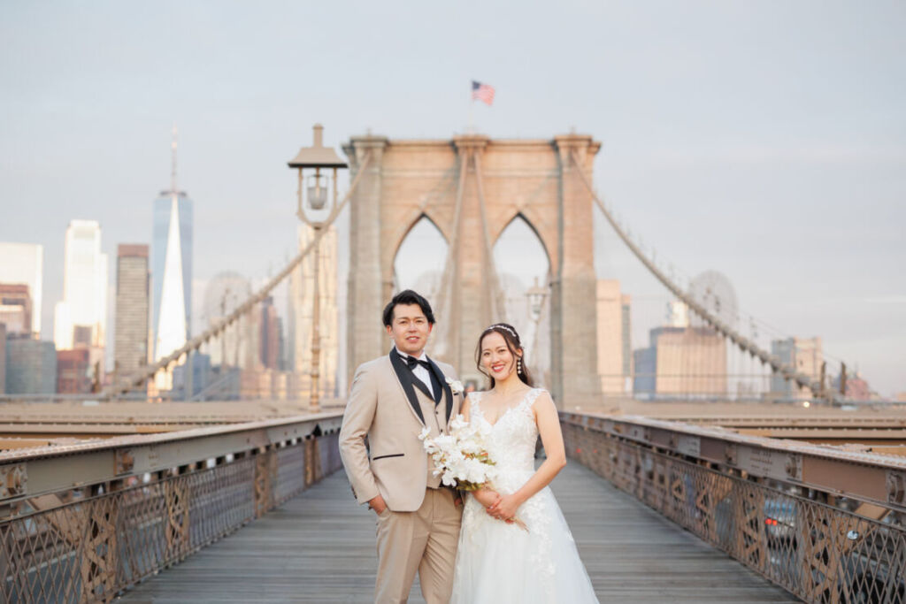 ニューヨークの前撮り|ウェディングフォト/ブルックリン橋に立つ花嫁と花婿。