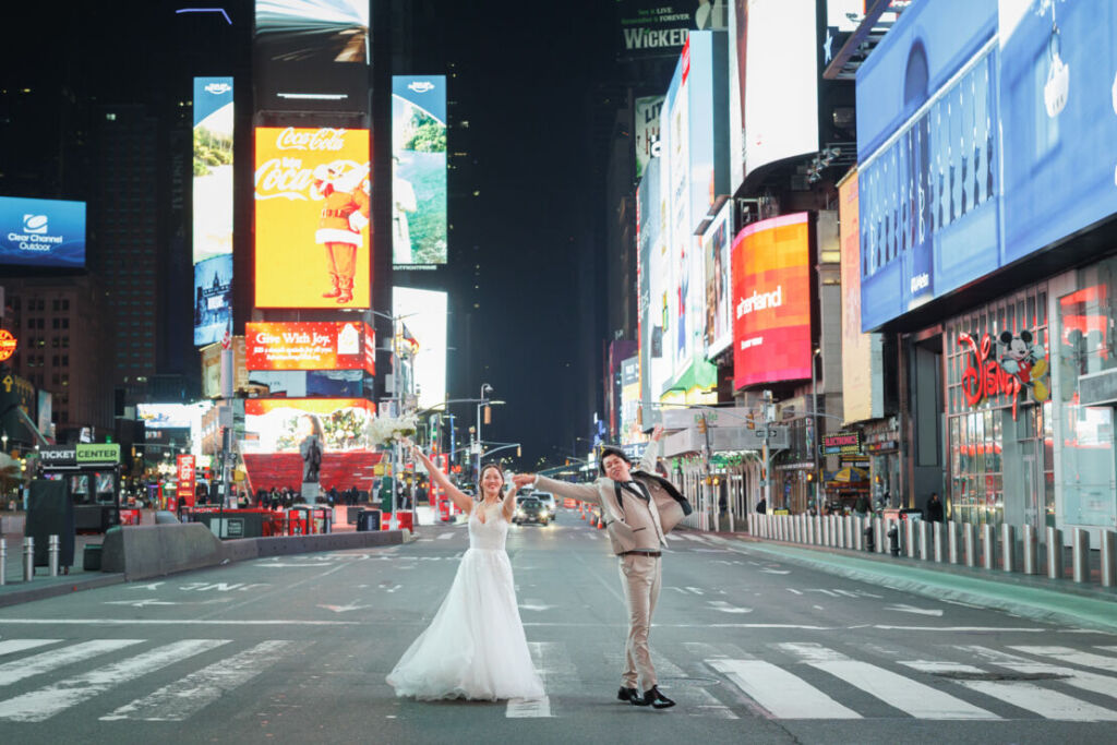 ニューヨークの前撮り|ウェディングフォト/タイムズスクエアの横断歩道で体いっぱいの伸ばすお二人。