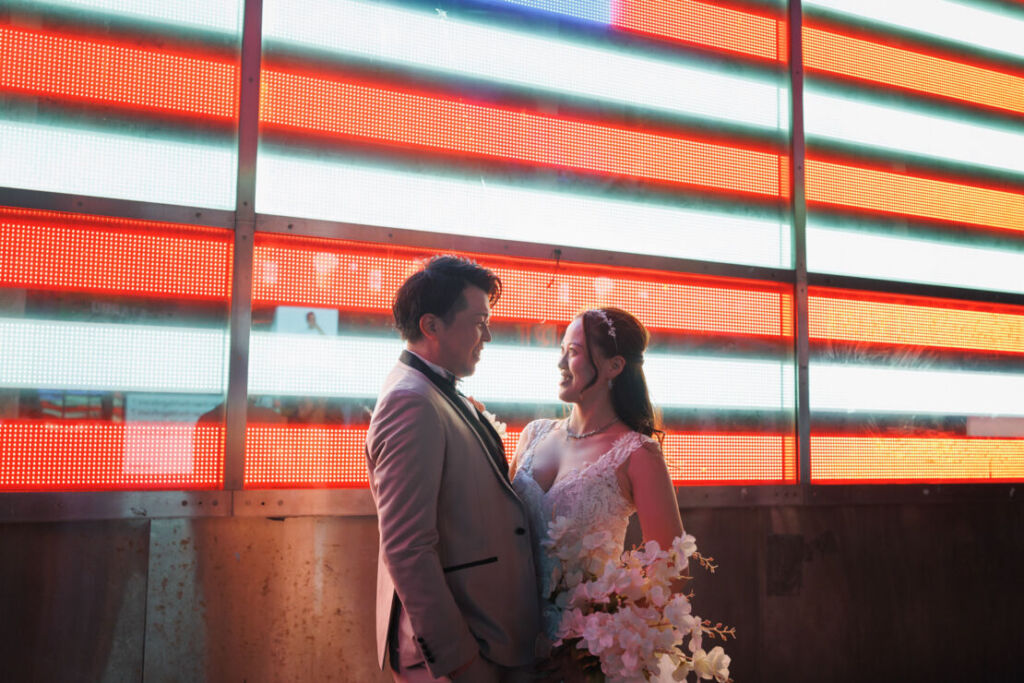 ニューヨークの前撮り|ウェディングフォト/タイムズスクエアの電光掲示板の前で見つめあうお二人。