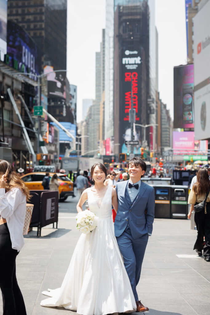 ニューヨークでフォトウェディング|前撮り/タイムススクエアを歩く花嫁さまと花婿さま。