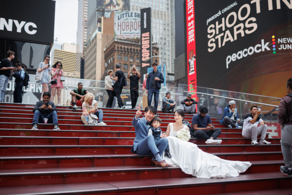 ニューヨークでフォトウェディング|前撮り/タイムズスクエアの赤い階段に座るご家族。