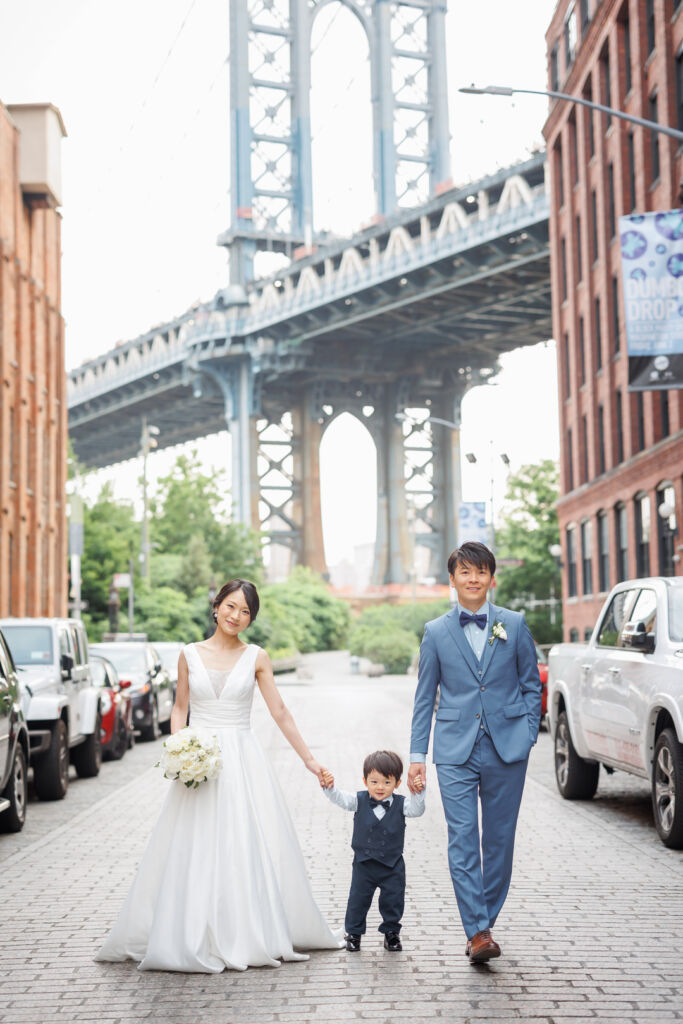 ニューヨークでフォトウェディング|前撮り/ワシントンストリートで、お子様の手を握るご夫婦。