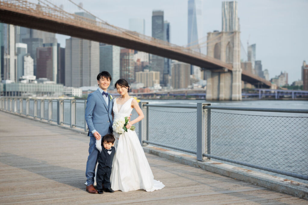 ニューヨークでフォトウェディング|前撮り/マンハッタンのスカイラインを背景にウェディング姿のご家族３人。