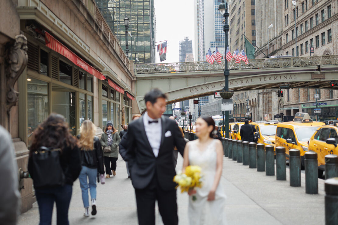 ニューヨークでウェディングフォト|前撮り/グランドセントラル駅の外を歩く花嫁と花婿。