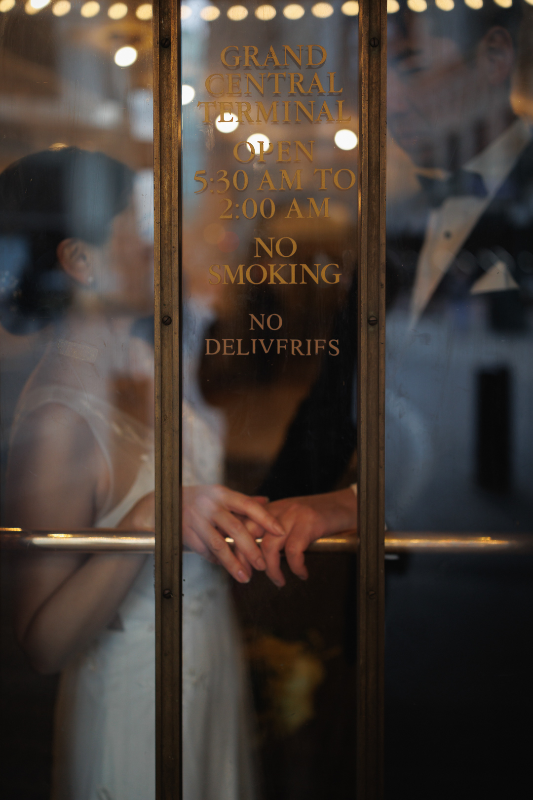 ニューヨークでウェディングフォト|前撮り/グランドセントラル駅の扉の前で語りあう花嫁と花婿。