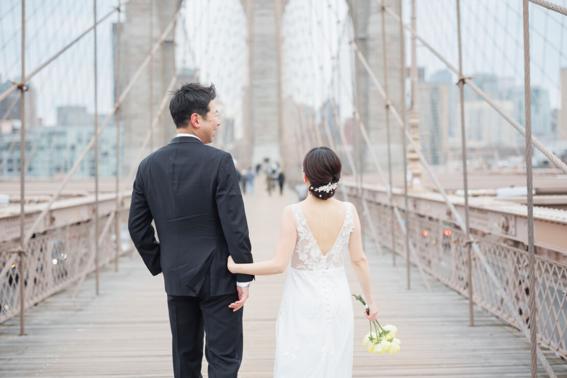 ニューヨークでウェディングフォト|前撮り/ブルックリン橋に立つ花嫁と花婿。