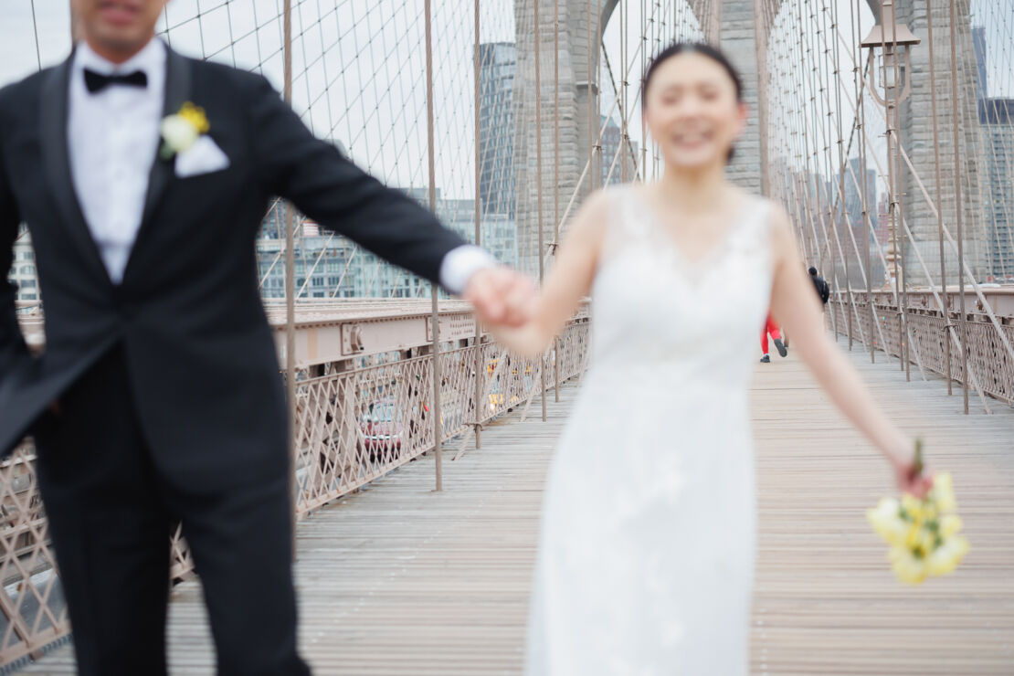 ニューヨークでウェディングフォト|前撮り/ブルックリン橋で手をつなぐカップル。